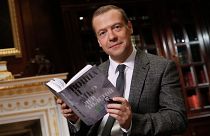 The then Russian Prime Minister Dmitry Medvedev poses as he reads Leo Tolstoy's "War and Peace" aloud as he takes part in a 60-hour marathon on national television in 2015