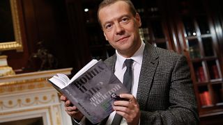 The then Russian Prime Minister Dmitry Medvedev poses as he reads Leo Tolstoy's "War and Peace" aloud as he takes part in a 60-hour marathon on national television in 2015