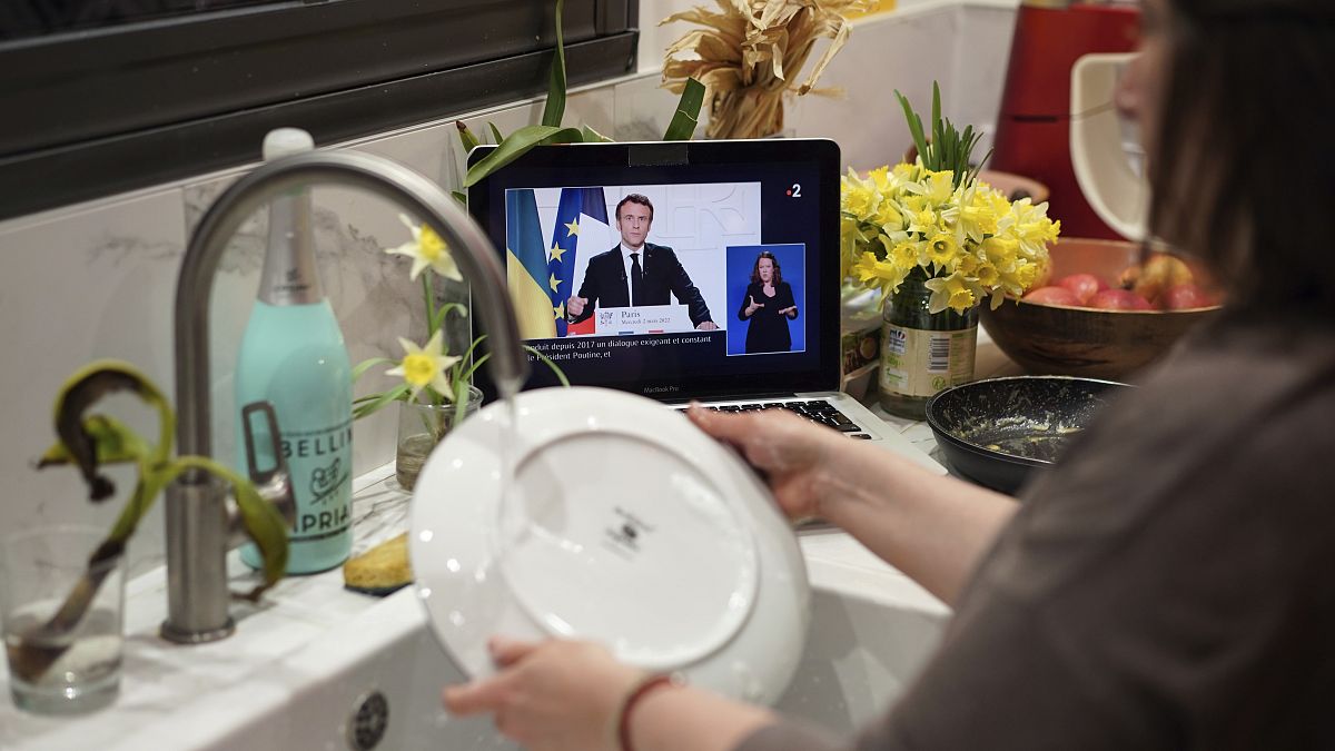 Женщина моет посуду под обращение Эммануэля Макрона к нации. Лион, Франция. 2 марта 2022 года