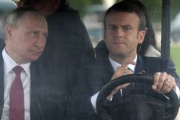 French President Emmanuel Macron, right, drives an electric golf car with Russian President Vladimir Putin in the garden of the Versailles Palace in 2017.
