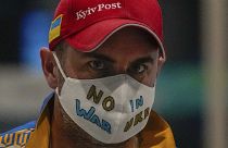 A Ukrainian journalist wearing a face mask bearing the words "No War in Ukraine" walks through the Main Media Center ahead of the 2022 Winter Paralympics in Beijing, China