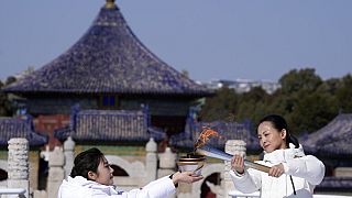 Participants light the flame during a lighting ceremony for the torch relay of the 2022 Winter Paralympics at the Temple of Heaven in Beijing, March 2, 2022.