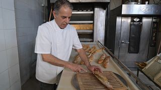 خباز يعرض الخبز في مخبزة في منطقة المنزه - تونس. 2022/02/27