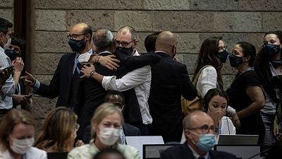 Delegates hug at the Fifth session of the United Nations Environment Assembly (UNEA 5) after negotiating a global plastic treaty.