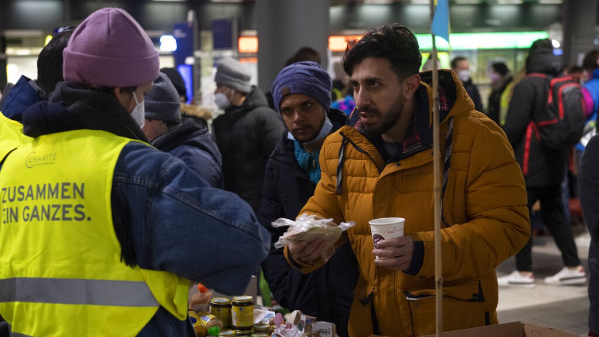 Refugees who have arrived from Ukraine are given warm drinks and something to eat at a counter after their arrival at Berlin's main train station, Germany, Thursday, March 3, 