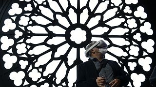 A man uses a virtual reality glasses at the stand of Orange to visit Notre Dame Cathedral at the MWC (Mobile World Congress) in Barcelona on March 2, 2022.