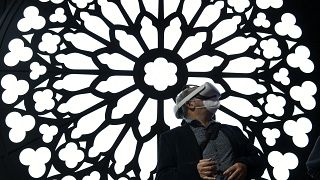 A man uses a virtual reality glasses at the stand of Orange to visit Notre Dame Cathedral at the MWC (Mobile World Congress) in Barcelona on March 2, 2022. 