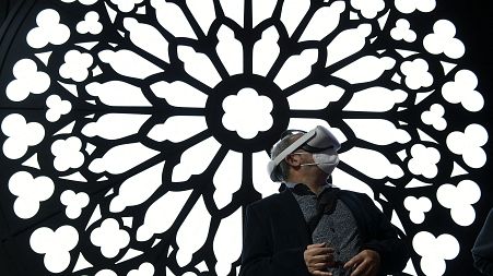 A man uses a virtual reality glasses at the stand of Orange to visit Notre Dame Cathedral at the MWC (Mobile World Congress) in Barcelona on March 2, 2022. 