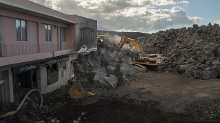 Una excavadora retira lava de las inmediaciones del volcán en las Islas Canarias de La Palma, España, el viernes 28 de enero