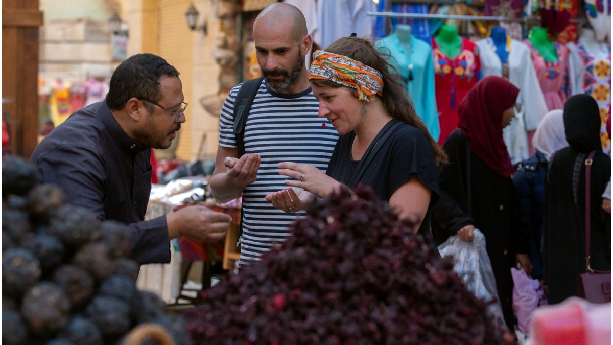 سائحان فرنسيان ليتيسيا وكريستوف يشترون التوابل من السوق التقليدي في أسوان بمصر