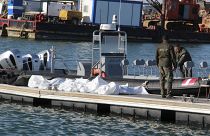 خفر السواحل التونسية يقفون بجوار جثث المهاجرين في ميناء صفاقس وسط تونس