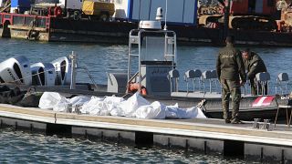 خفر السواحل التونسية يقفون بجوار جثث المهاجرين في ميناء صفاقس وسط تونس
