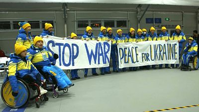 Paralympic athletes and members of the Ukrainian National Paralympic Committee display a banner and call for peace in Ukraine, shortly before the opening ceremony of the Beiji