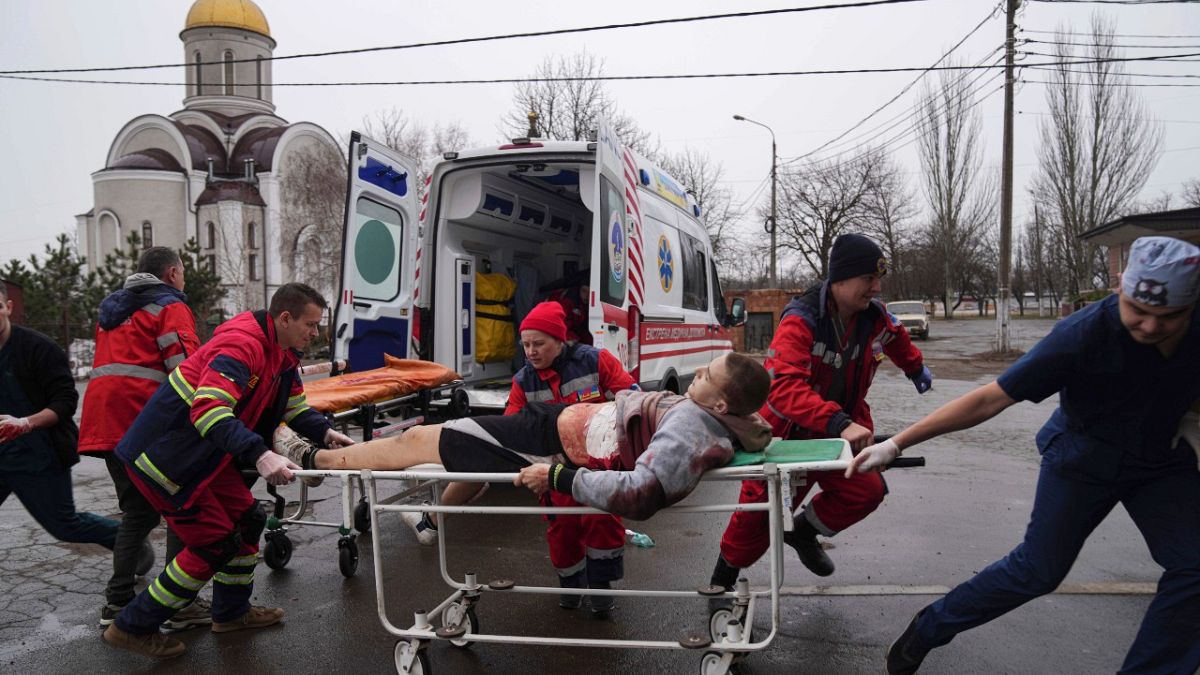 مسعفون ينقلون رجلًا مصابًا في ماريوبول، شرق أوكرانيا