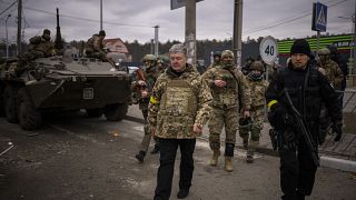 Former Ukrainian President Petro Poroshenko surrounded by Ukrainian soldiers arrives at a defence position on the outskirts of Kyiv, Ukraine, Saturday, March 5, 2022