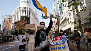 Manifestantes gritan consignas portando banderas y pancartas durante una marcha para denunciar la invasión rusa en Ucrania, en Tokio, el 5 de marzo de 2022. 