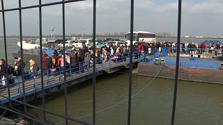 Ukrainians cross the Danube on a barge at the border with Romania.