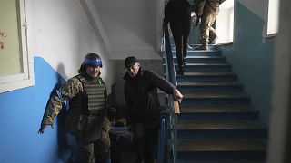 Katonák és civilek sérülteket mentenek egy mariupoli kórházban
