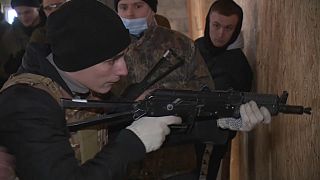 A volunteer in Lviv, Ukraine learning how to fire a gun. 