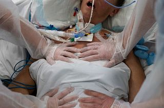 FILE - Nurses perform timed breathing exercises on a COVID-19 patient on a ventilator in the COVID-19 intensive care unit at the la Timone hospital in Marseille, December 2021