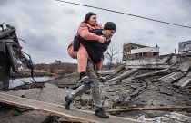 Egy férfi visz a hátán egy nőt menekülés közben, egy rögtönzött ösvényen kelnek át az ukrajnai Irpin városából, 2022. március 6-án, vasárnap. 