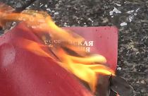 متظاهر روسي في بلغراد يحرق جواز سفره الروسي احتجاجا على غزو أوكرانيا.