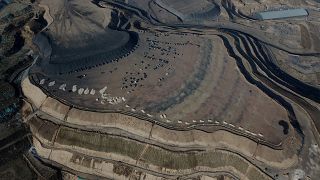 This aerial view shows coal being loaded onto trucks near a coal mine in Datong, China's northern Shanxi province, 2021.