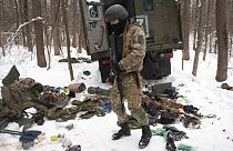 Un voluntario de las Fuerzas de Defensa Territorial de Ucrania inspecciona un vehículo militar dañado en las afueras de Kharkiv, el lunes 7 de marzo de 2022