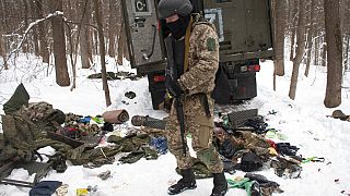 Un voluntario de las Fuerzas de Defensa Territorial de Ucrania inspecciona un vehículo militar dañado en las afueras de Kharkiv, el lunes 7 de marzo de 2022