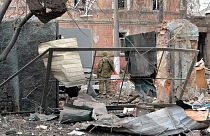 Украинский военнослужащий смотрит на разрушения после обстрела Харькова 7 марта 2022 года.