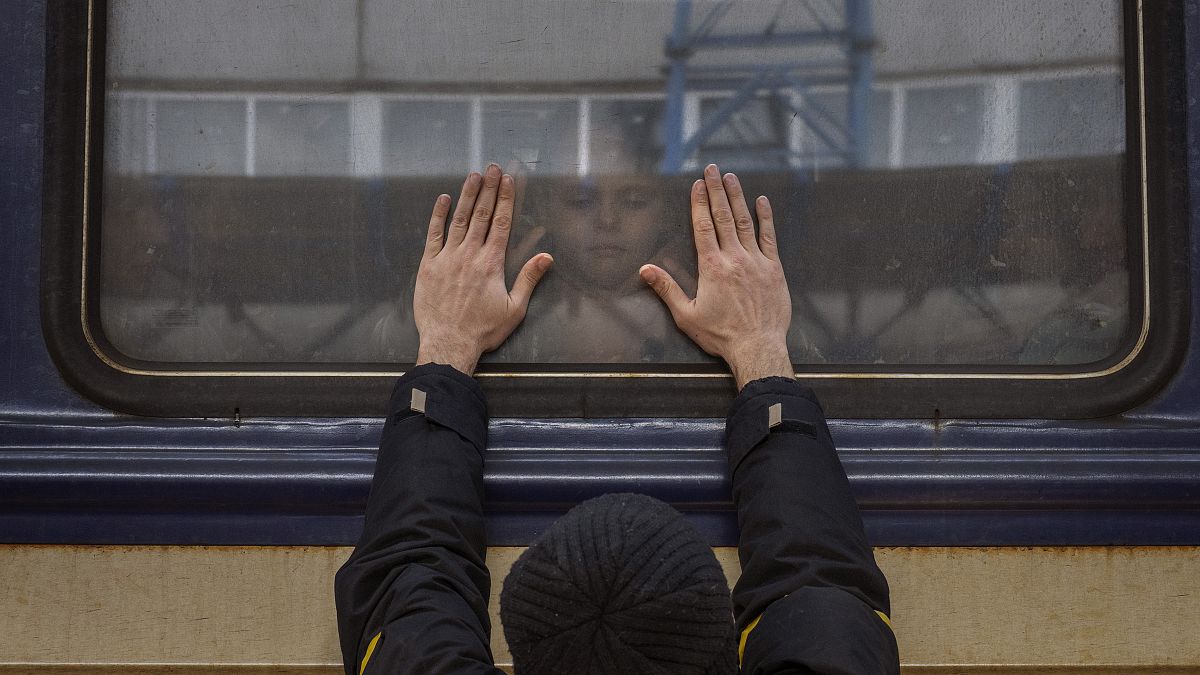 Aleksander, 41, presses his palms against the window as he says goodbye to his daughter Anna, 5, on a train to Lviv at the Kyiv station, Ukraine. March 4. 2022