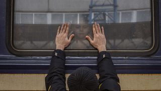 Aleksander (41) presst seine Handflächen gegen das Fenster, während er sich von seiner Tochter Anna (5) in einem Zug nach Lviv am Bahnhof von Kiew verabschiedet. 4. März 2022.
