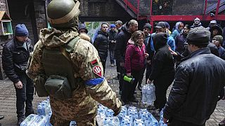 Militares ucranianos distribuem água às pessoas em Mariupol
