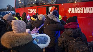 Flüchtlinge, meist Frauen mit Kindern, warten nach ihrer Ankunft am Grenzübergang in Medyka, Polen, auf den Einstieg in einen Bus, 08.03.2022