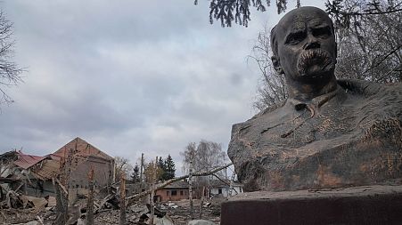 A bust of Taras Shevchenko, Ukrainian poet and national symbol, stands against the background of a runined house of culture in Byshiv, 40 kilometres west of Kyiv
