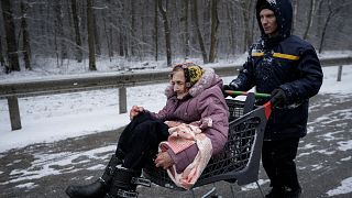 Une dame âgée est transportée dans un chariot après avoir été évacuée d'Irpin, dans la banlieue de Kyiv en Ukraine, mardi 8 mars 2022.