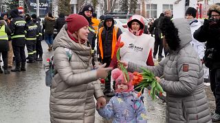 Women being gifted flowers just after crossing border into Romania from Ukraine.