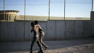 Two migrants pictured on the Spanish side of the fences separating the enclave of Melilla from Morocco.