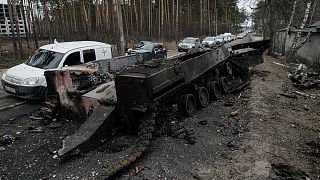 Cars drive past a destroyed Russian tank as a convoy of vehicles evacuating civilians leaves Irpin, on the outskirts of Kyiv, Ukraine, Wednesday, March 9, 2022.