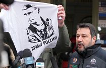 Przemysl's mayor Wojciech Bakun holds up a t-shirt with the likeness of Russian President Vladimir Putin and the words "The Russian Army" as he stands alongside Matteo Salvini