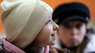 Annamaria Moslovska, a ten-year-old from Kharkiv, eastern Ukraine, smiles in a waiting room at the train station in Zahony, Hungary, Monday, March 7, 2022.