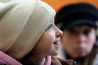 Annamaria Moslovska, a ten-year-old from Kharkiv, eastern Ukraine, smiles in a waiting room at the train station in Zahony, Hungary, Monday, March 7, 2022.