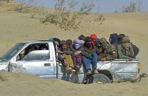  مهاجرون أفغان يركبون شاحنة صغيرة على طول طريق صحراوي باتجاه الحدود الأفغانية الإيرانية في نمروز، في 17 فبراير 2022