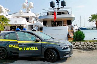An Italian Financial Police car is parked in front of the superyacht “Lena", belonging to Gennady Timchenko.