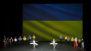 Ballerini del Kyiv City Ballet si esibiscono davanti alla bandiera ucraina, proiettata su uno schermo al Théâtre du Chatelet di Parigi