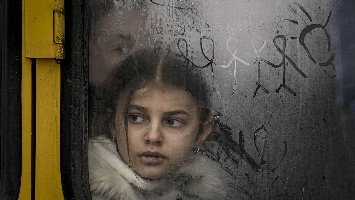 A child looks out a steamy bus window with drawings on it as civilians are evacuated from Irpin, on the outskirts of Kyiv, Ukraine, Wednesday, March 9, 2022