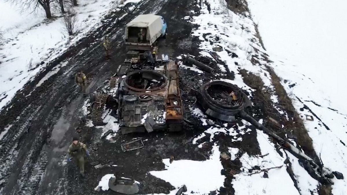 Ukrainische Soldaten neben zerstörtem Panzer