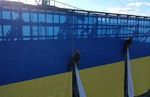 Kletterer installieren ukrainische Riesenflagge auf dem Dach des LTV-Gebäudes in Riga