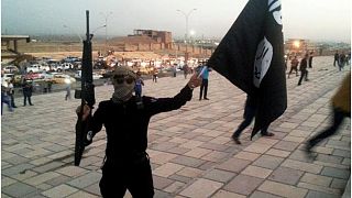 مقاتل لتنظيم داعش يحمل عمل التنظيم