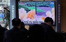People watch a TV showing a file image of North Korea's missile launch during a news program at the Seoul Railway Station in Seoul, South Korea, March 5, 2022.